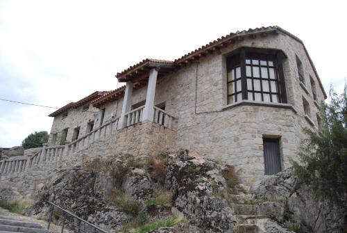 an old stone building on a hill with stairs at Alojamientos El Castillo in El Berrueco