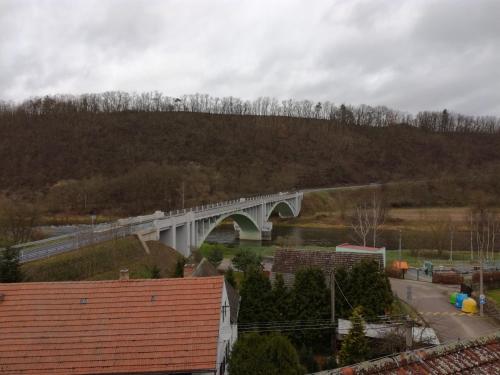 a bridge over a river with a mountain in the background at Hotel Berounka in Liblín