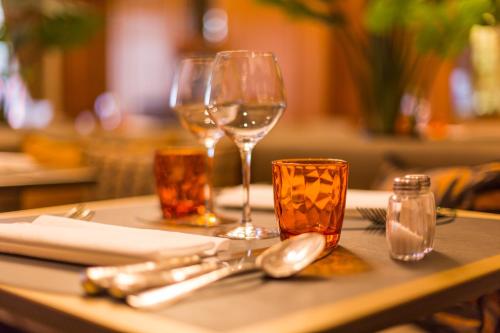 a table with two wine glasses and utensils on it at Hotel Royal in De Panne