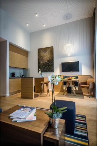 a living room with a table and a kitchen at The Wellem, in The Unbound Collection by Hyatt in Düsseldorf