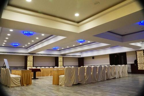 a banquet hall with tables and chairs and blue lights at SilverCloud Hotel and Banquets in Ahmedabad