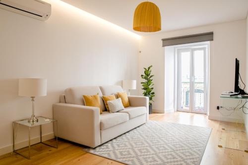 - un salon avec un canapé blanc et un tapis dans l'établissement Loving Chiado, à Lisbonne