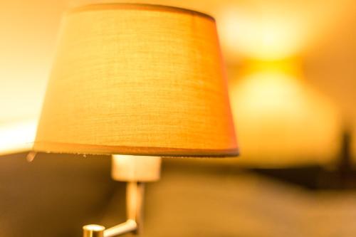 a lamp with a brown shade on top of it at Hotel Royal in De Panne