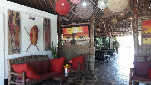a living room with a couch and a table at African Dream Cottages - Diani Beach in Diani Beach