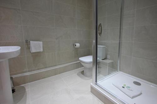 a bathroom with a shower and a toilet and a sink at The Castle Collection 14 Cook Street in Liverpool