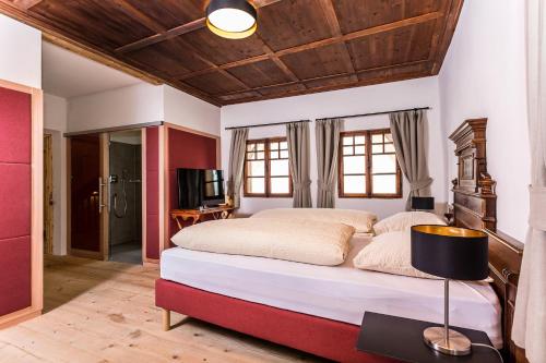 a bedroom with a large bed with a wooden ceiling at Gasthaus Babsi in Soprabolzano