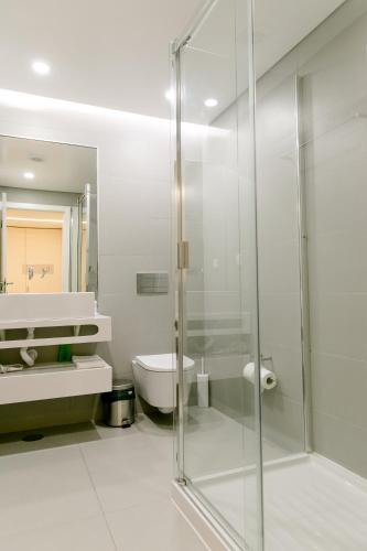 a bathroom with a glass shower and a toilet at Loving Chiado in Lisbon