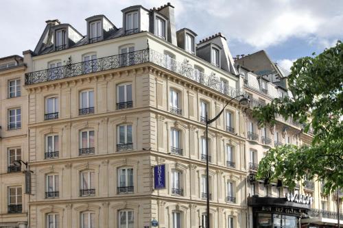 a large white building with a balcony at Contact Hôtel Alizé Montmartre in Paris