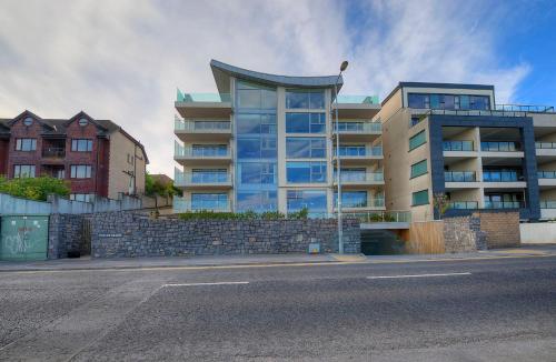 a large building with glass windows on the side of a street at Tur an Tsaile - Galway Lakeside Apartments in Galway