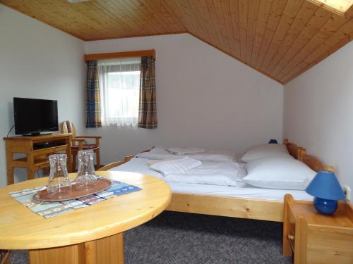 代什特納的住宿－Pension Arnika，小房间设有一张床和一张桌子