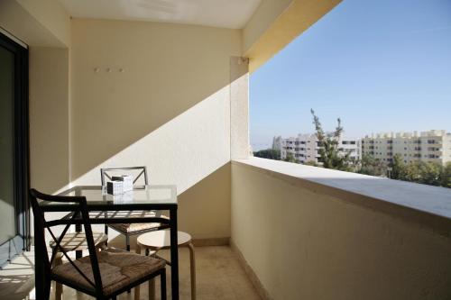 balcón con mesa, sillas y ventana en Parque das Nações - Fil New Apartment en Lisboa