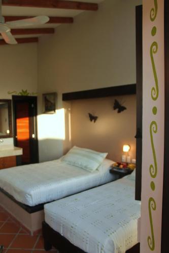 two beds in a hotel room with at Hotel Boutique La Casona de Don Porfirio in Jonotla