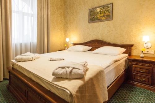 a bedroom with a bed with two pillows on it at West Park Hotel in Kyiv