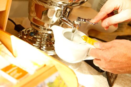 a person cutting a piece of paper with a sewing machine at Flair Hotel Nieder in Bestwig