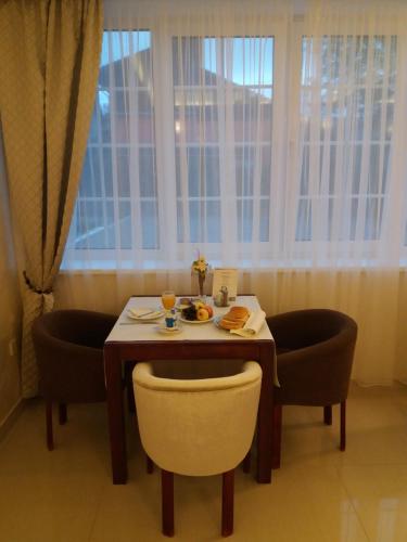 a table and chairs with a plate of food on it at Hotel Orion in Ivanec