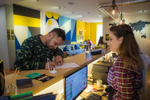 a man and a woman sitting at a desk with a computer at SAHIL Hostel & Hotel in Baku