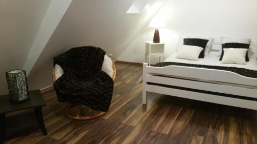 - une chambre avec un lit et une chaise dans l'établissement La Vénitienne, à Colmar
