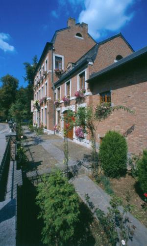 a large brick building with plants in front of it at Hotel IL Castellino in Chaudfontaine
