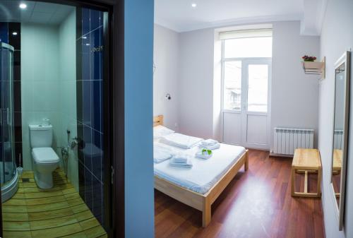 a bedroom with a bed and a bathroom with a shower at SAHIL Hostel & Hotel in Baku