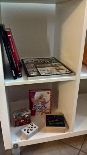 a shelf with books and other books on it at ACERO ROSSO B&B in Franciacorta in Erbusco