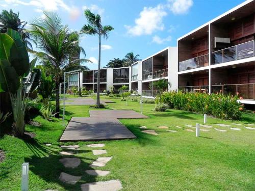 um grande edifício com palmeiras em frente em Barra Grande Exclusive Residence em Barra Grande