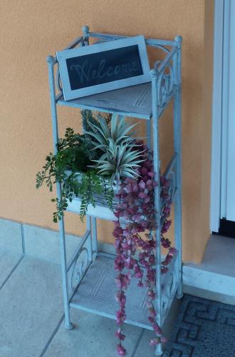 a sign on a stand with plants on it at Dimora La Risorgiva in Ca' di David