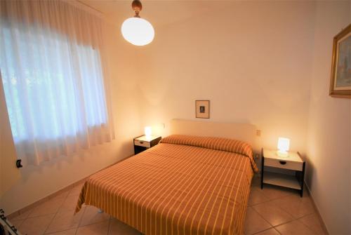 una camera con un letto e due comodini di Villa Mary a Lignano Sabbiadoro