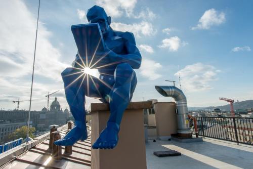 a statue of a man sitting on top of a building at MeetMe23 in Prague