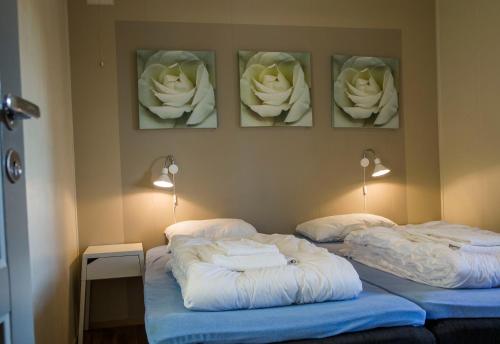 two beds in a room with flowers on the wall at Birkebeineren Hotel & Apartments in Lillehammer