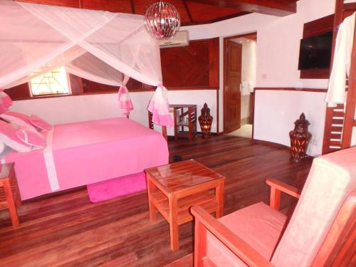 a bedroom with a bed and a table at Edena Kely in Mahajanga
