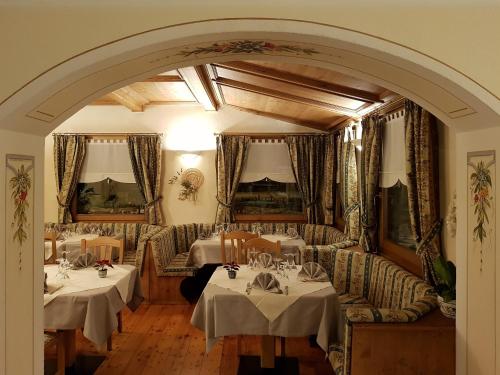 a restaurant with two tables and chairs and an archway at Hotel Cima Piazzi in Valdidentro