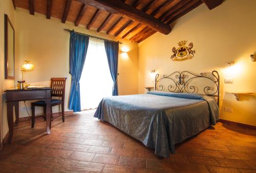 een slaapkamer met een bed, een bureau en een raam bij Tenuta dei Principi in Marina di Grosseto