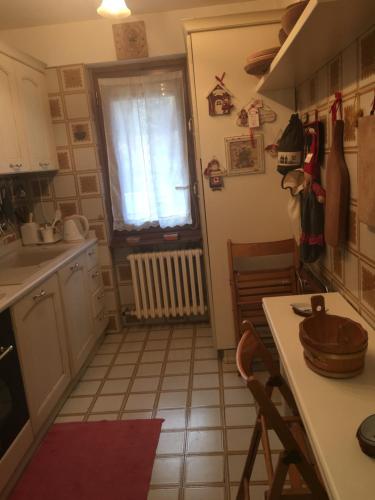 uma pequena cozinha com uma mesa e uma janela em Casa Alagna em Alagna Valsesia