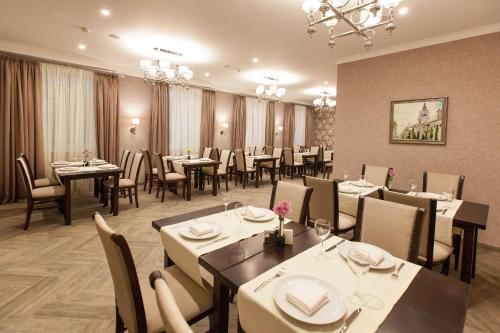 West Park Hotel في كييف: غرفة طعام مع طاولات وكراسي في مطعم