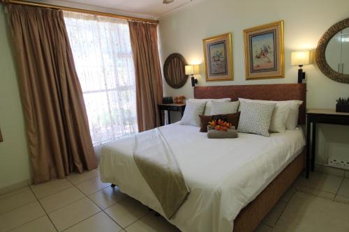 a bedroom with a large bed with flowers on it at Wilger Guesthouse in Centurion
