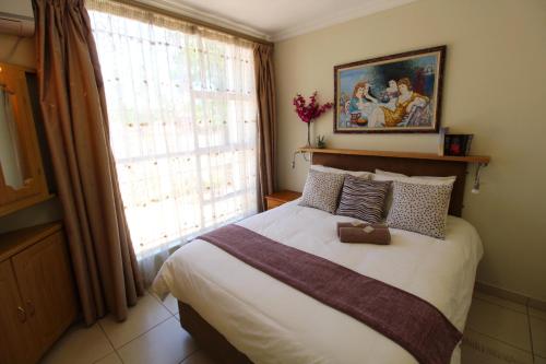 a bedroom with a large bed and a window at Wilger Guesthouse in Centurion