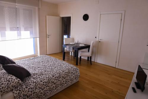 a bedroom with a table and a bed and a desk at 4YOU APARTMENTS - PONTI ROMANI in Padova