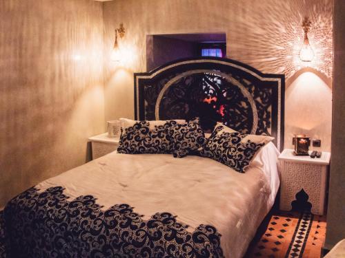 a bedroom with a black and white bed with pillows at Riad Golf Stinia 1 in Meknès