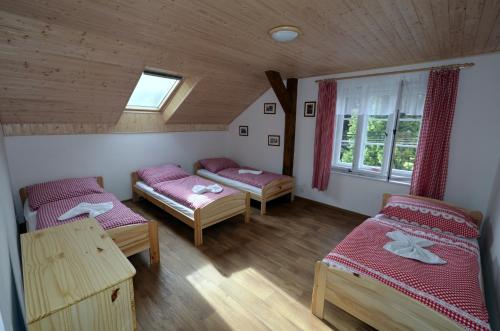 オストロフにあるHospoda U Lípyのベッド3台と窓が備わる客室です。