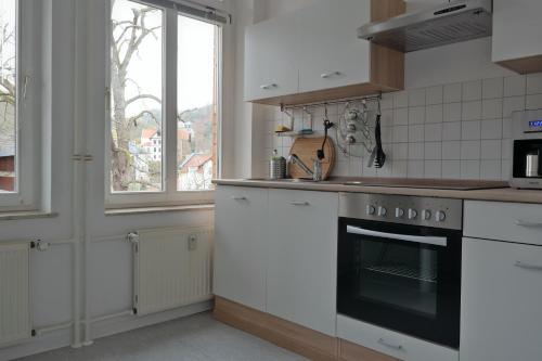 een keuken met een fornuis en een raam bij Ferienwohnung Wartburgblick in Eisenach