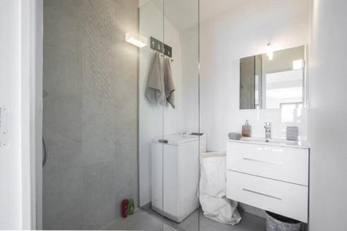 une salle de bain blanche avec un lavabo et un miroir dans l'établissement LE GILLY 6 - F3 EXCEPTIONNEL, VUE MER, MODERNE, CLIMATISATION, Vieux-Nice, à Nice