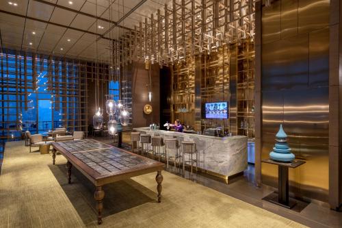 a restaurant with a bar with a table and chairs at Pan Pacific Yangon in Yangon