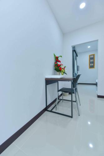 a table and a chair in a room at Jarat Mansion in Surin