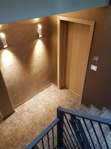 a hallway with a door with lights on the wall at Hotel Baril in Haţeg