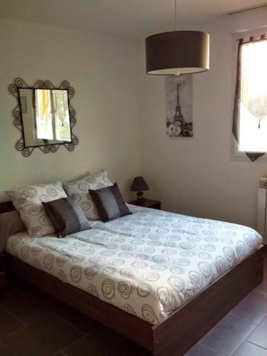 une chambre avec un grand lit avec des oreillers dans l'établissement GITE DE L'OISILLIERE, à Huisseau-sur-Cosson