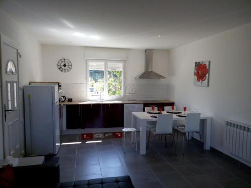 a kitchen with a white table and chairs in it at GITE DE L'OISILLIERE in Huisseau-sur-Cosson