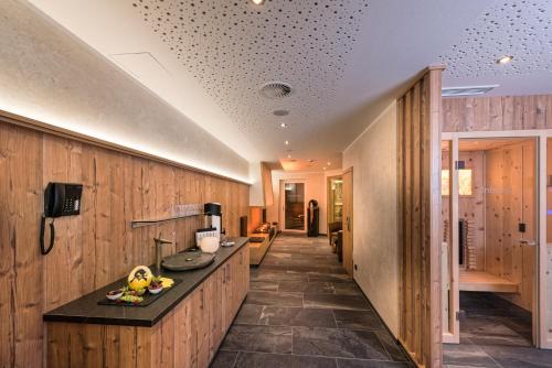 a hallway with wood paneling and a kitchen with a counter at Hotel Eldorado in Ischgl
