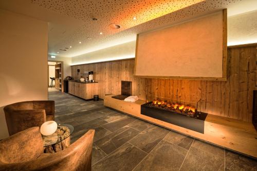 a lobby with a fireplace in the middle of a room at Hotel Eldorado in Ischgl