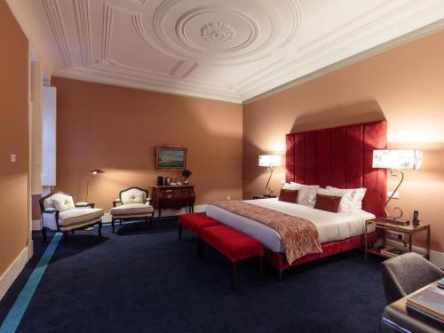 a bedroom with a large bed with a red headboard at Dear Lisbon - Bordalo Palace Chiado in Lisbon