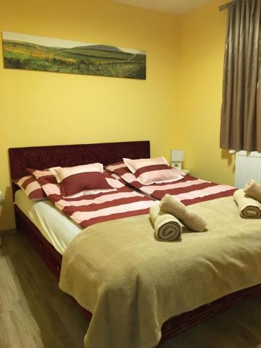 1 dormitorio con 1 cama grande y toallas. en BB Apartman, en Villány